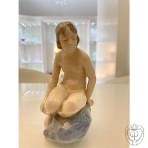 Royal Copenhagen Statuina ragazzo seduto su roccia